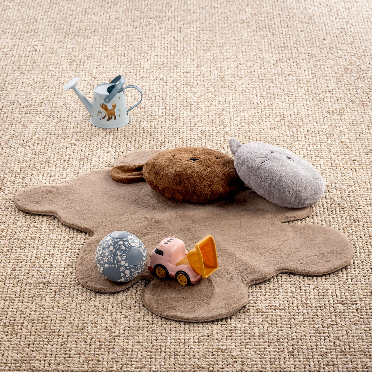 Kinderzimmerteppich in Tierform mit Spielzeug, aus der Vogelperspektive fotografiert.