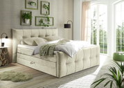 Boxspringbett in einem hellen Schlafzimmer mit großen Fenstern, Pflanzen und moderner Dekoration, seitliche Perspektive