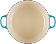 Ronde braadpan met crèmekleurige binnenkant en blauwe handgrepen, van bovenaf gezien