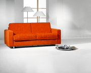 Leuchtend orangefarbenes Zweisitzer-Sofa mit breiten Armlehnen und vier geteilten Polstern, frontal in einem hellen, modernen Wohnraum präsentiert