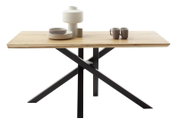 Moderner Esstisch mit Holzplatte und schwarzem Metallgestell, seitliche Perspektive, dekoriert mit Geschirr und Vase.