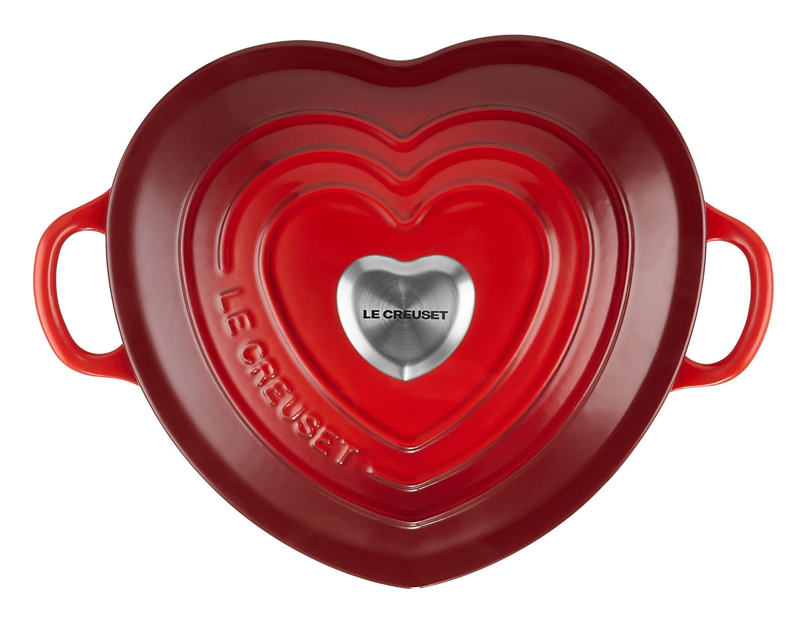Herzförmiger, kirschroter Bräter von oben mit zwei Griffen und einem silbernen Knauf in der Mitte, Le Creuset-Logo sichtbar.