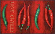 Fußmatte mit roten und grünen Chilischoten auf rotem Hintergrund, Draufsicht