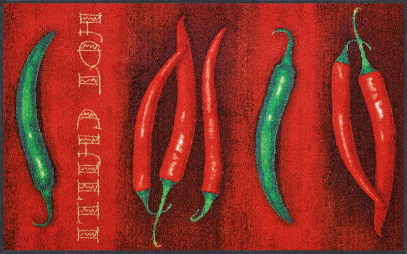 Fußmatte mit roten und grünen Chilischoten auf rotem Hintergrund, Draufsicht
