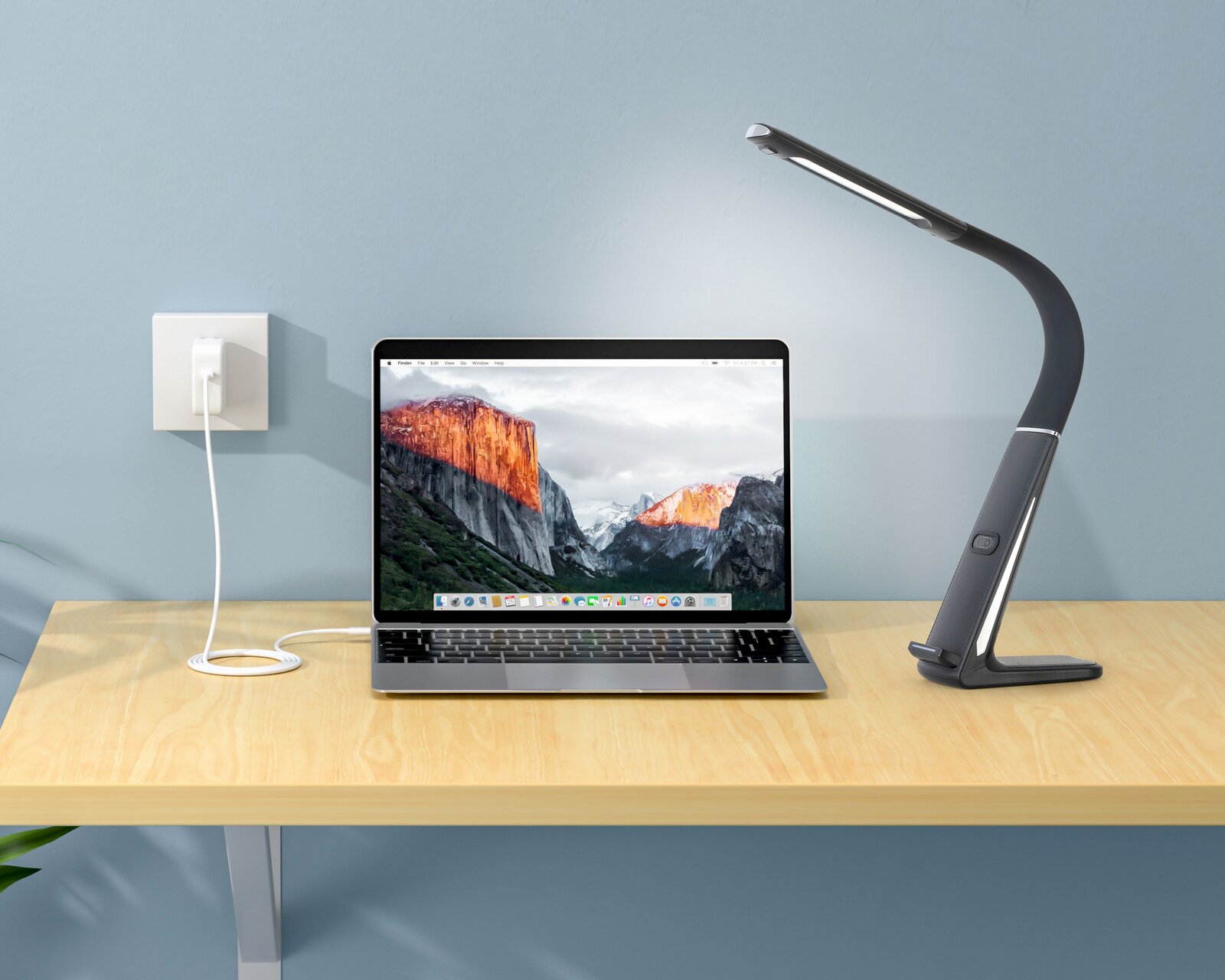 LED-Schreibtischleuchte in seitlicher Perspektive neben einem Laptop auf einem Holztisch.