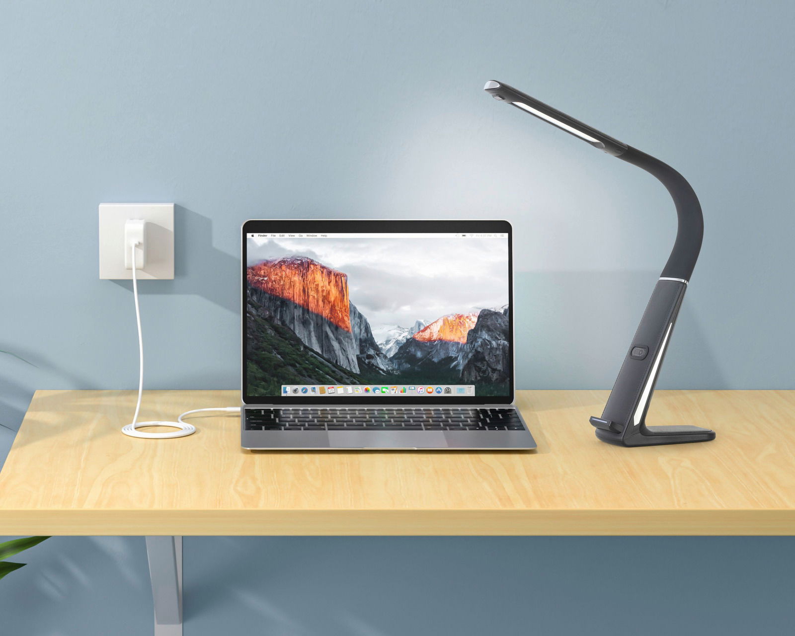 Novel LED-Schreibtischleuchte LED-Schreibtischleuchte in seitlicher Perspektive neben einem Laptop auf einem Holztisch.