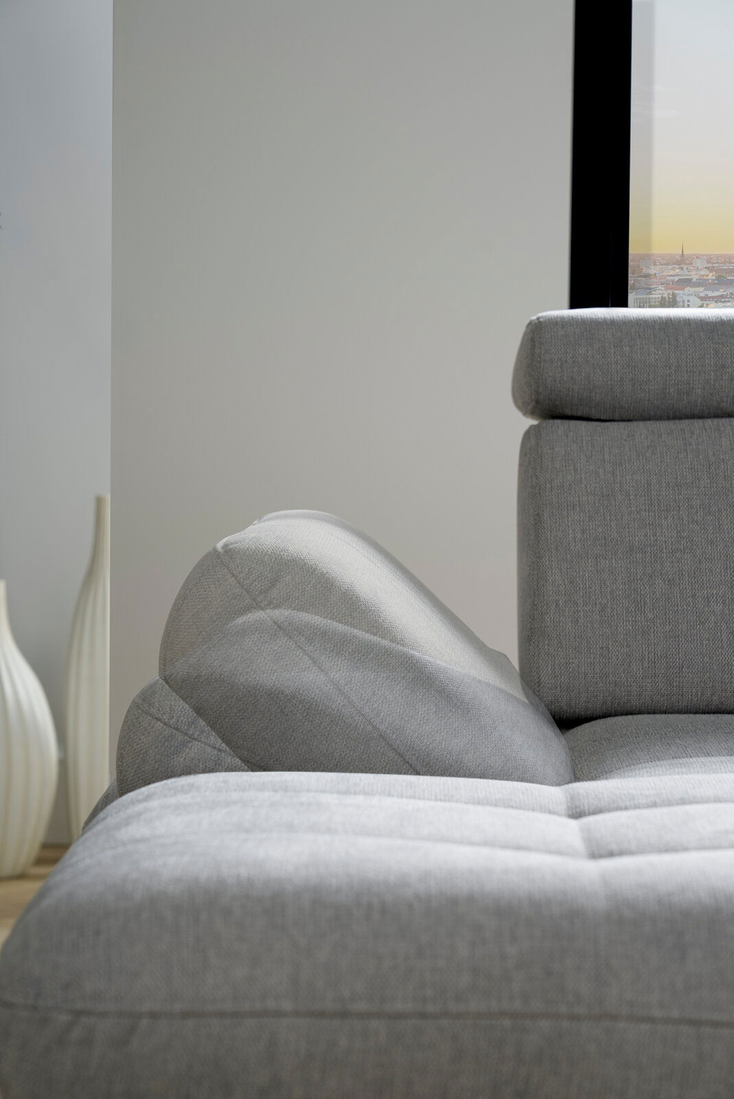 Graues Sofa mit verstellbarer Rückenlehne und Armlehne, seitliche Perspektive
