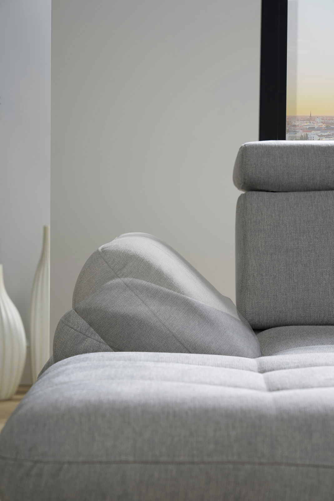Graues Sofa mit verstellbarer Rückenlehne und Armlehne, seitliche Perspektive