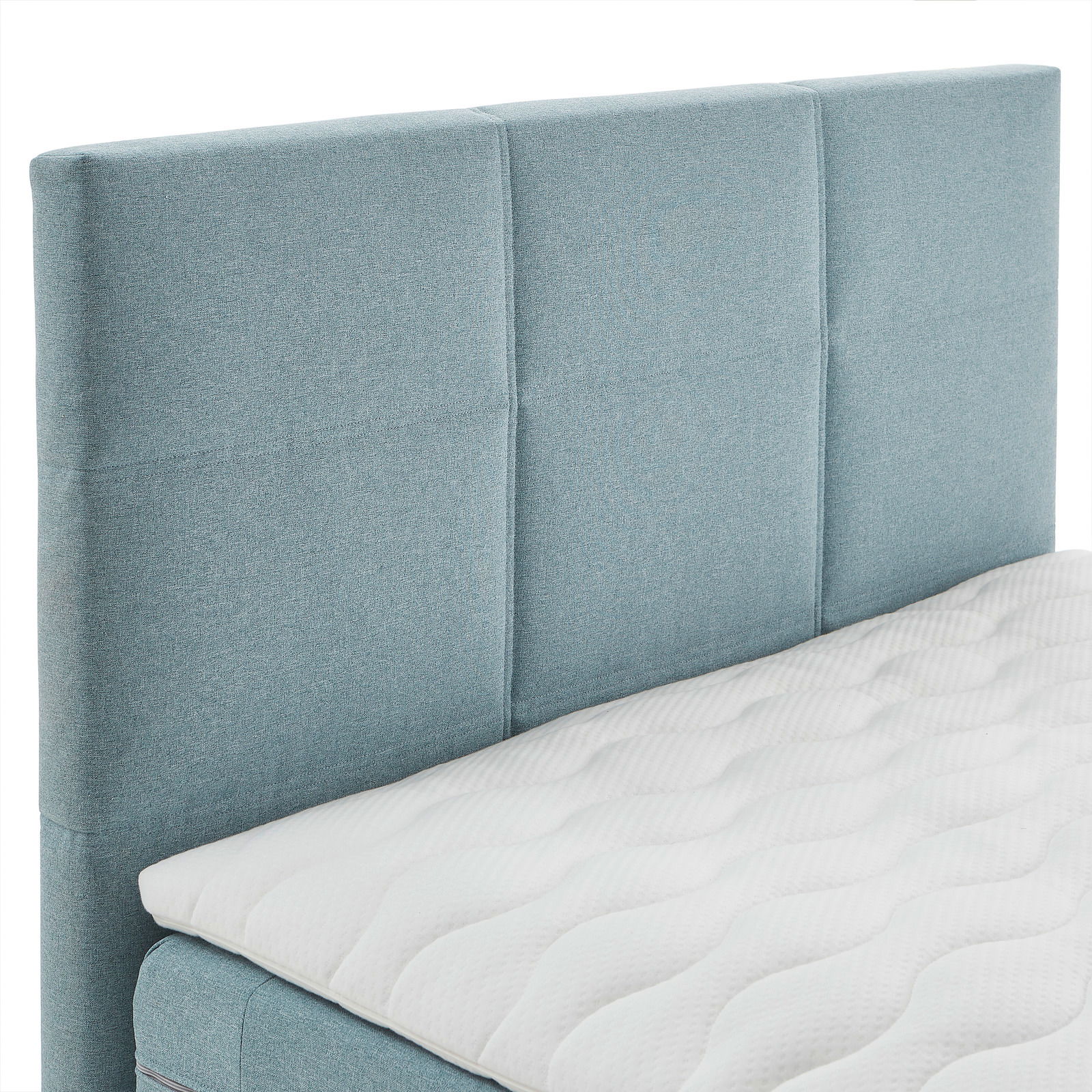 Boxspringbett mit hellblauem Kopfteil und weißer Matratze, seitliche Perspektive