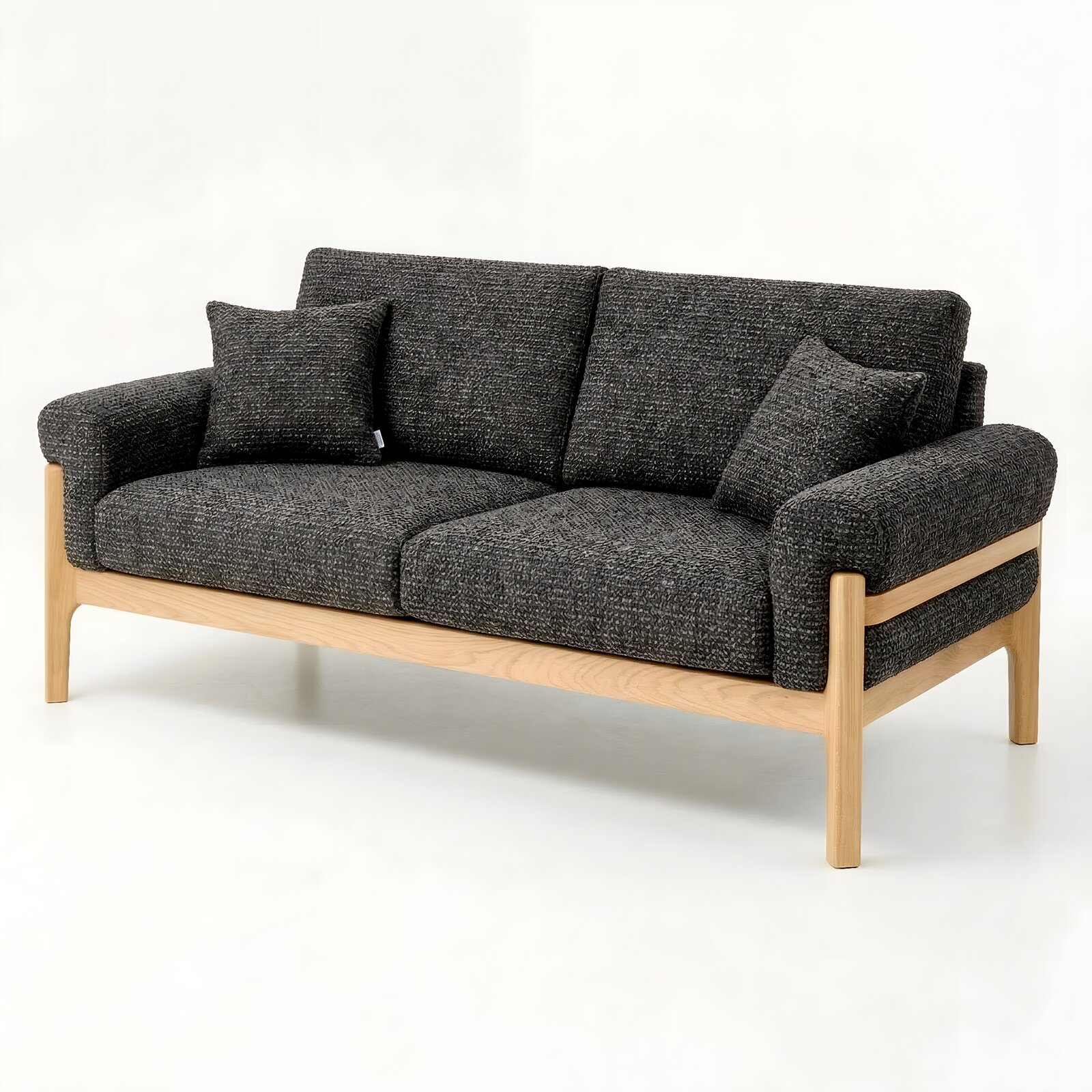 Donkergrijze tweezitsbank met gestructureerde stoffen bekleding, twee rugkussens en een licht houten frame, vrijstaand tegen een witte achtergrond, in een schuin vooraanzicht vanaf links.
