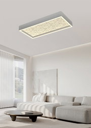 Moderne LED-Deckenleuchte in rechteckiger Form, von unten betrachtet, in einem stilvollen Wohnzimmer mit hellen Möbeln.