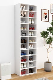 Hoher weißer Schuhschrank mit vielen offenen Fächern, gefüllt mit verschiedenen Schuhpaaren, in einem hellen Raum mit Holzfußboden; Perspektive: leicht schräg von vorne links (3/4-Ansicht).