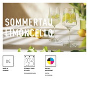 Zwei elegante Limoncellogläser mit Zitronenmotiv auf einem Tisch, umgeben von frischen Zitronen und grünen Blättern, seitliche Perspektive.