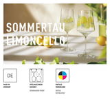Zwei elegante Limoncellogläser mit Zitronenmotiv auf einem Tisch, umgeben von frischen Zitronen und grünen Blättern, seitliche Perspektive.
