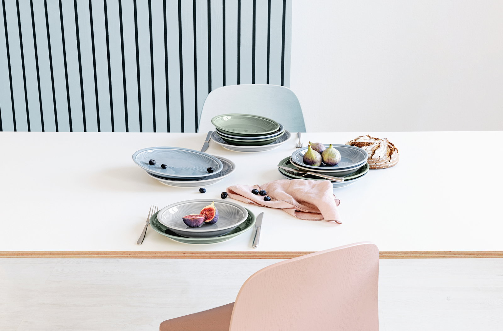 Elegantes 12-teiliges Tafelset in sanften Pastelltönen, von oben fotografiert, mit Feigen und Beeren dekoriert.