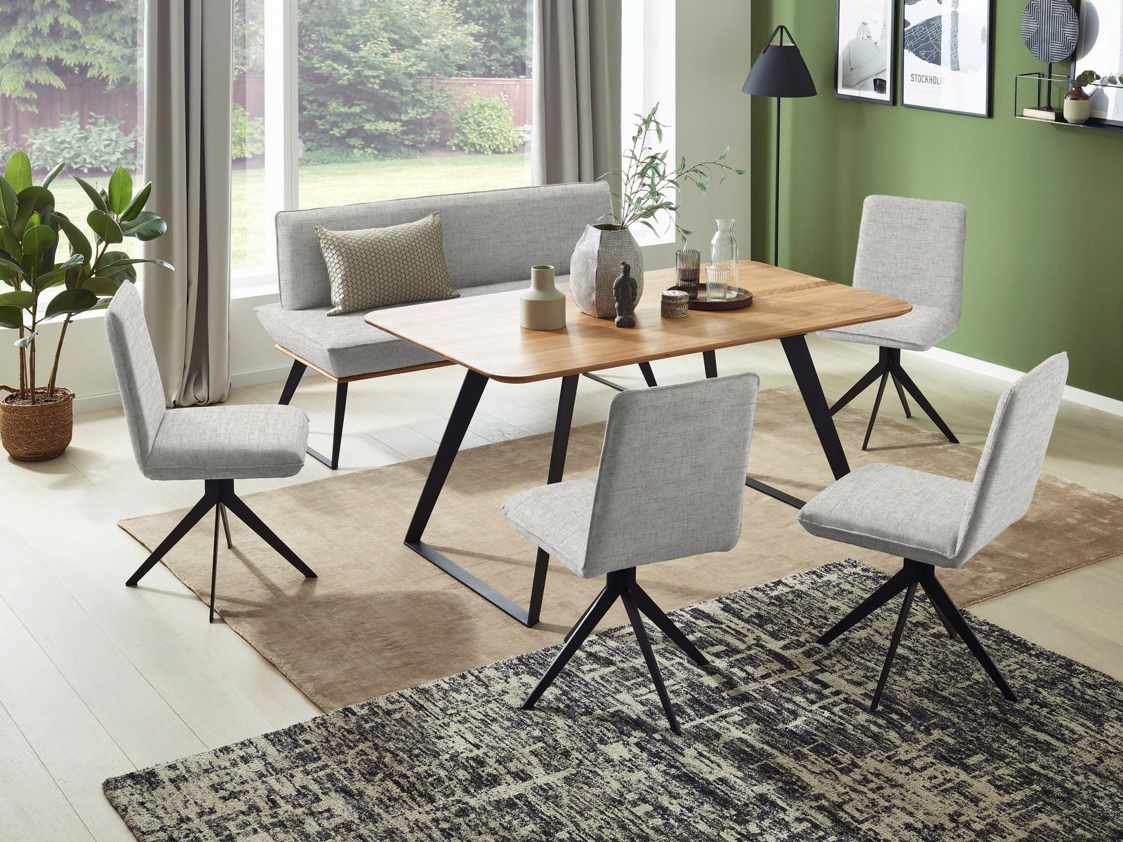 Voleo Bank 140 cm MALIBU Esszimmer mit moderner Bank und Stühlen in hellgrauem Stoff, Holztisch und grüner Wand im Hintergrund, seitliche Perspektive