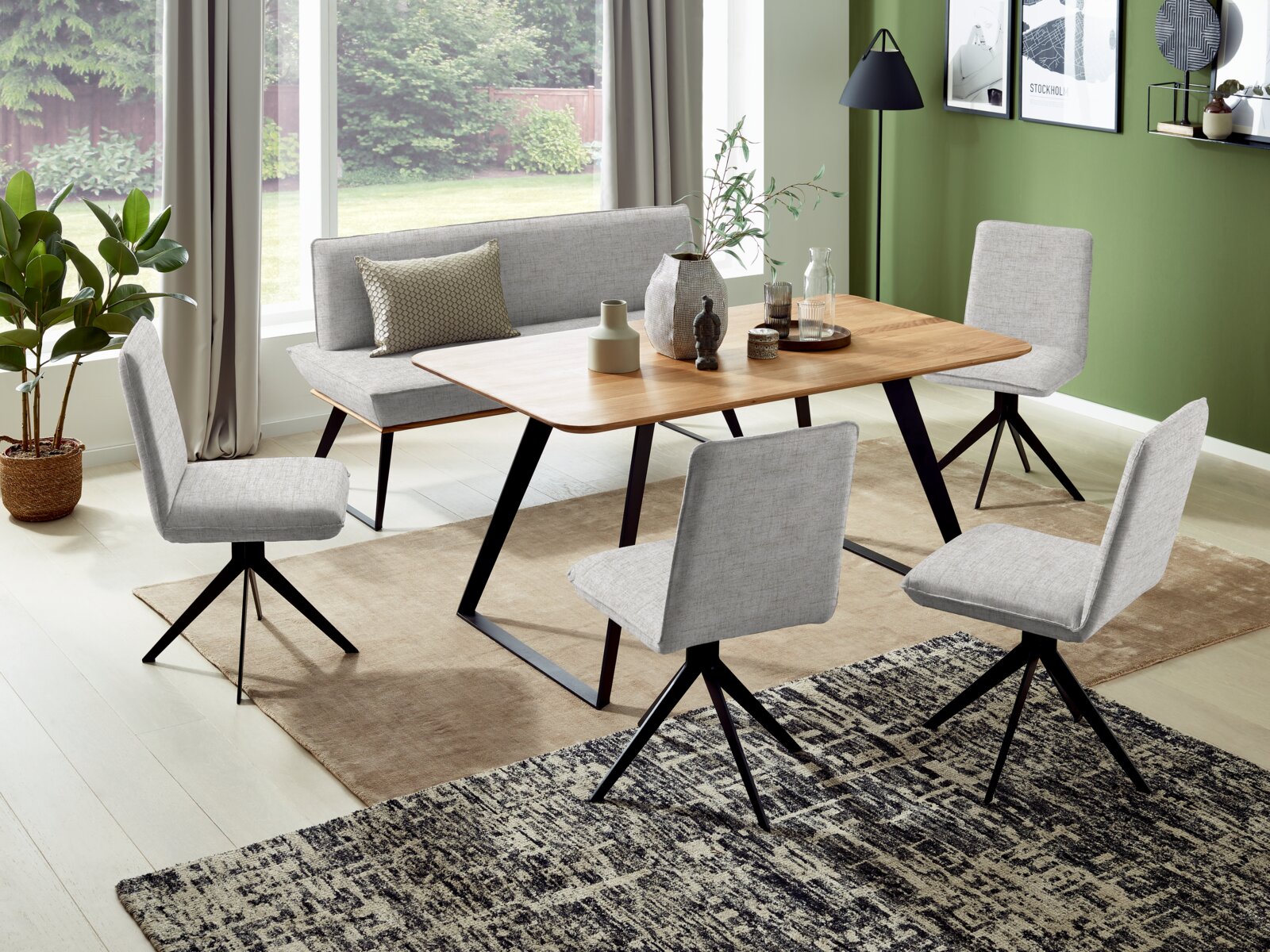 Voleo Bank 140 cm MALIBU Esszimmer mit moderner Bank und Stühlen in hellgrauem Stoff, Holztisch und grüner Wand im Hintergrund, seitliche Perspektive