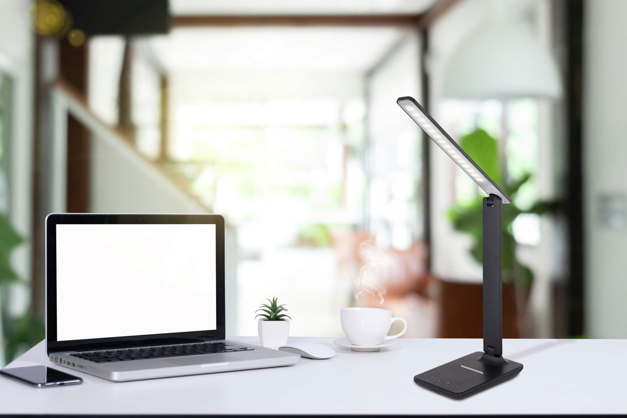 Schwarze Tischleuchte aus Kunststoff in einem modernen Büro, seitliche Perspektive.