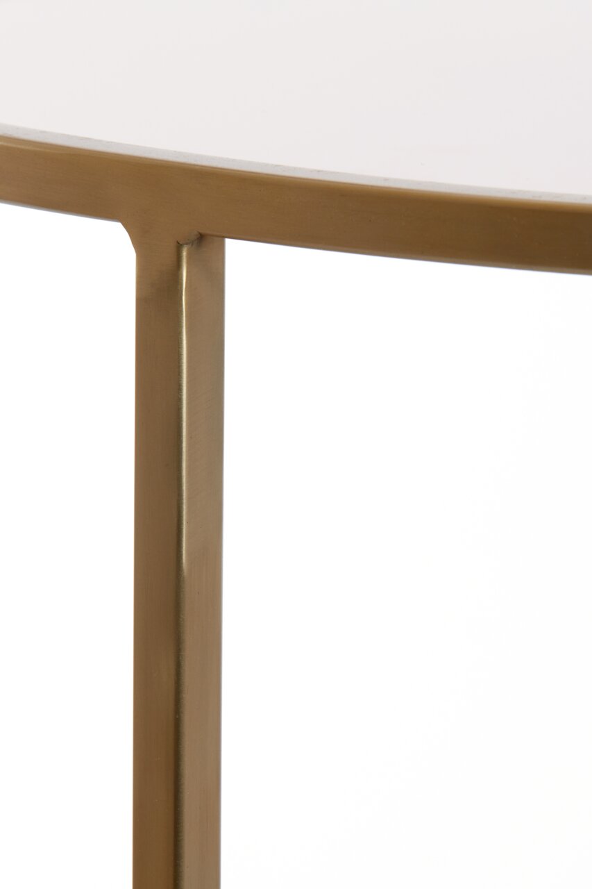 Nahaufnahme eines Couchtischs mit goldfarbenem Metallrahmen und weißer Tischplatte, seitliche Perspektive.