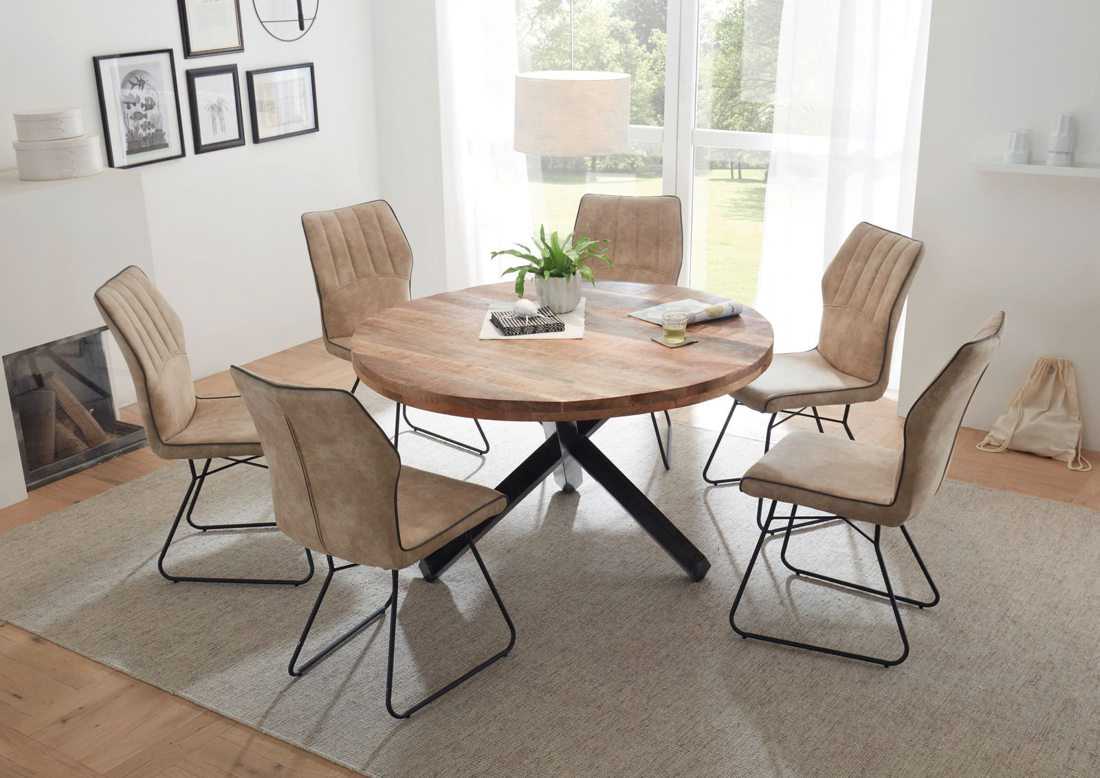 Runder Esstisch aus Holz mit schwarzem Kreuzfuß, umgeben von sechs beigen Stühlen, in einem hellen Raum mit großen Fenstern, aus der Vogelperspektive betrachtet.
