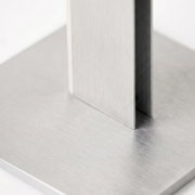 Detailansicht aus schräger Nahperspektive auf eine moderne Konstruktion aus gebürstetem Metall mit rechteckiger Bodenplatte und vertikalen Streben