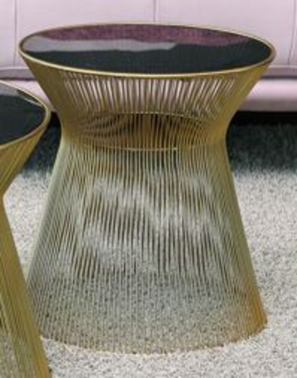 Moderne bijzettafel met gouden metalen poten en een zwart glazen blad, zijaanzicht