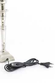 Nahaufnahme eines silbernen Lampenfußes mit Kabel und Schalter, seitliche Perspektive.