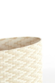 Nahaufnahme eines beige gemusterten Lampenschirms aus Stoff, seitliche Perspektive