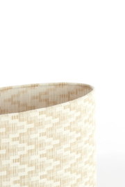 Nahaufnahme eines beige gemusterten Lampenschirms aus Stoff, seitliche Perspektive