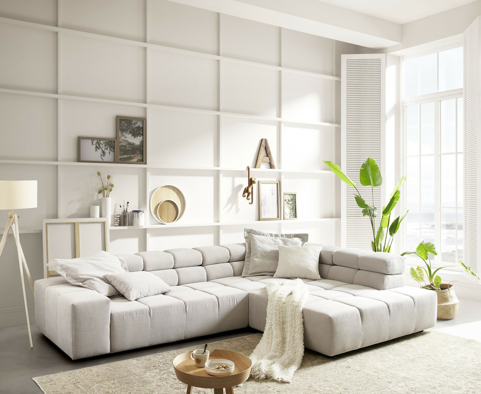 Helle und moderne Rundecke in einem stilvollen Wohnzimmer, mit Blick auf ein großes Fenster und dekorativen Elementen im Hintergrund.