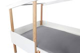 Hausbett mit weißem Rahmen und naturfarbenen Holzpfosten, seitliche Perspektive