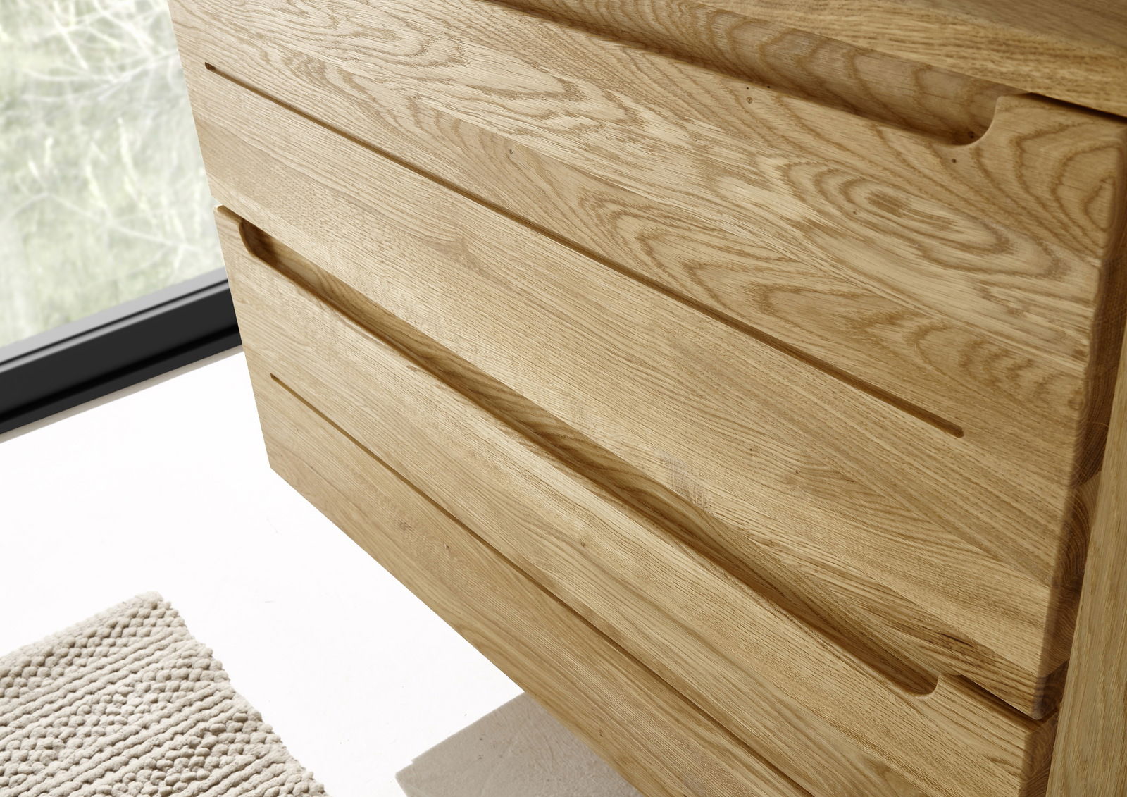 Nahaufnahme eines Waschtischunterschranks aus hellem Holz mit klaren Linien und natürlicher Maserung, seitliche Perspektive