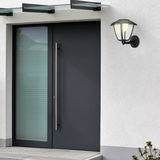 Moderne Akku-Außenwandleuchte an einer Hauswand neben einer Eingangstür, seitliche Perspektive