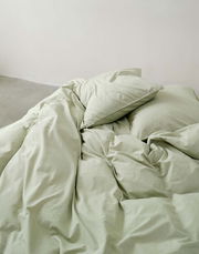 Grüne Bettwäsche 135x200cm, aus der Vogelperspektive fotografiert, auf einem Bett arrangiert.