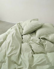 Grüne Bettwäsche 135x200cm, aus der Vogelperspektive fotografiert, auf einem Bett arrangiert.