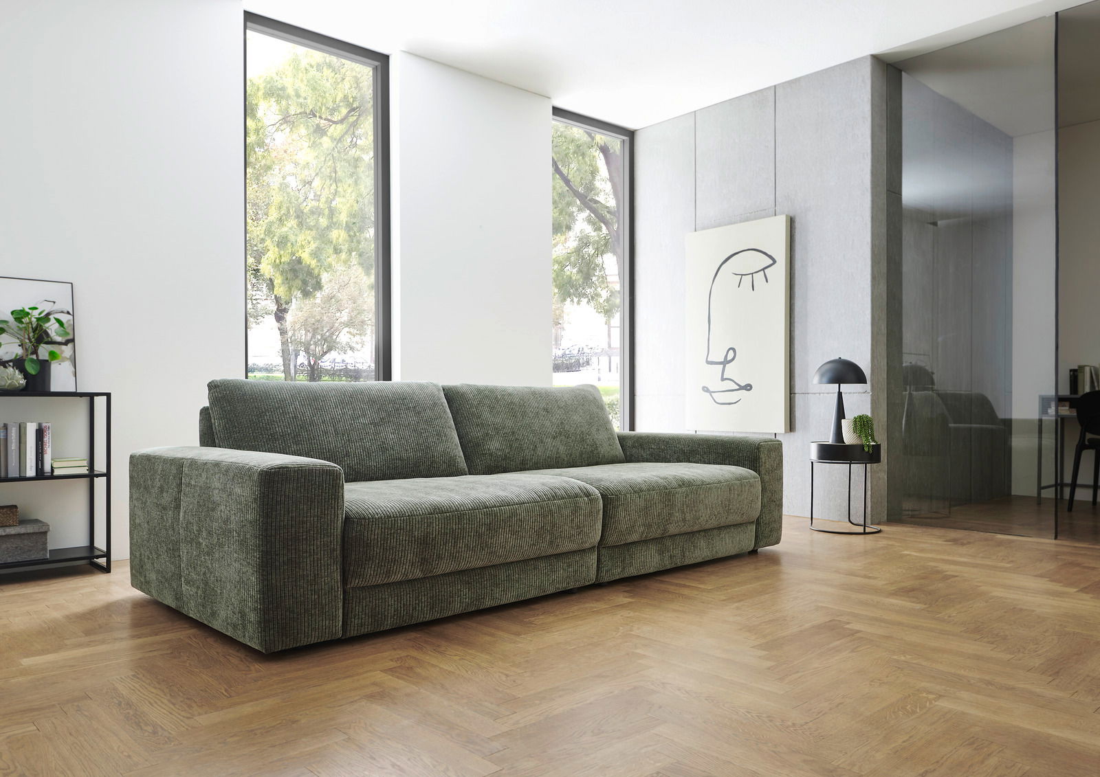 Grünes Megasofa in modernem Wohnzimmer, seitliche Perspektive