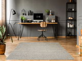 Moderner Frisé-Teppich in einem stilvollen Arbeitszimmer mit grauer Wand, Holzboden und eleganter Dekoration, aus der Vogelperspektive betrachtet.