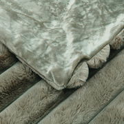 Detailansicht einer luxuriösen Felldecke mit weicher, plüschiger Textur in einem sanften Grauton.