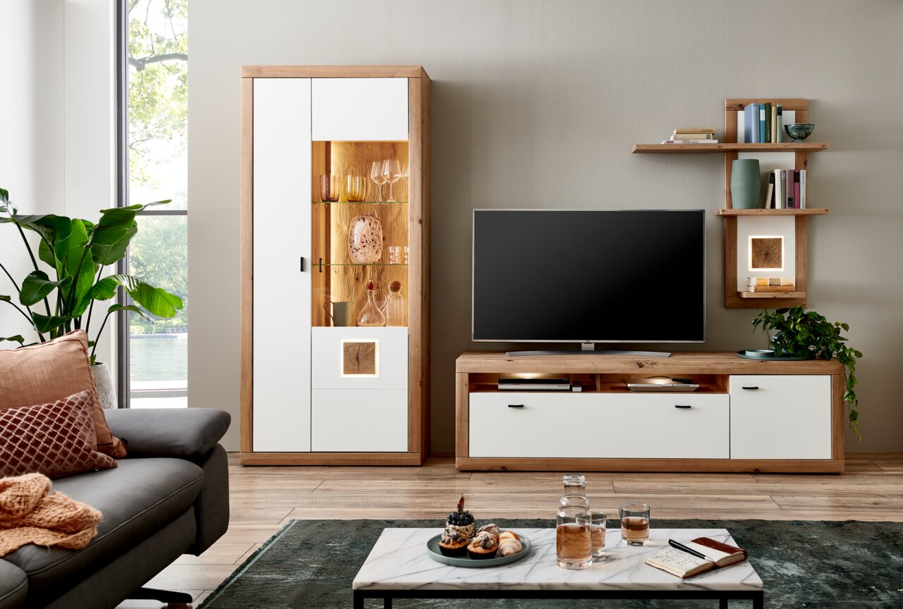 Moderne wandcombinatie BORKUM in licht hout en wit, bestaande uit een hoge kast met glazen paneel, een tv-meubel en een wandrek. Perspectief: vooraanzicht.