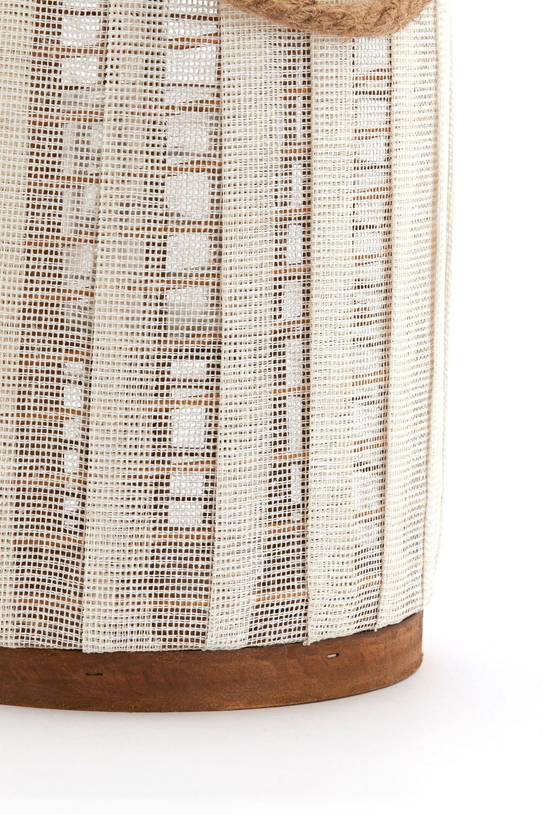 Nahaufnahme eines Windlichts mit einem Netzdesign und einem Holzsockel, seitliche Perspektive