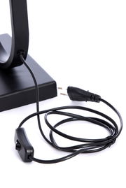 Nahaufnahme eines schwarzen Lampenfußes mit Kabel und Schalter, seitliche Perspektive.