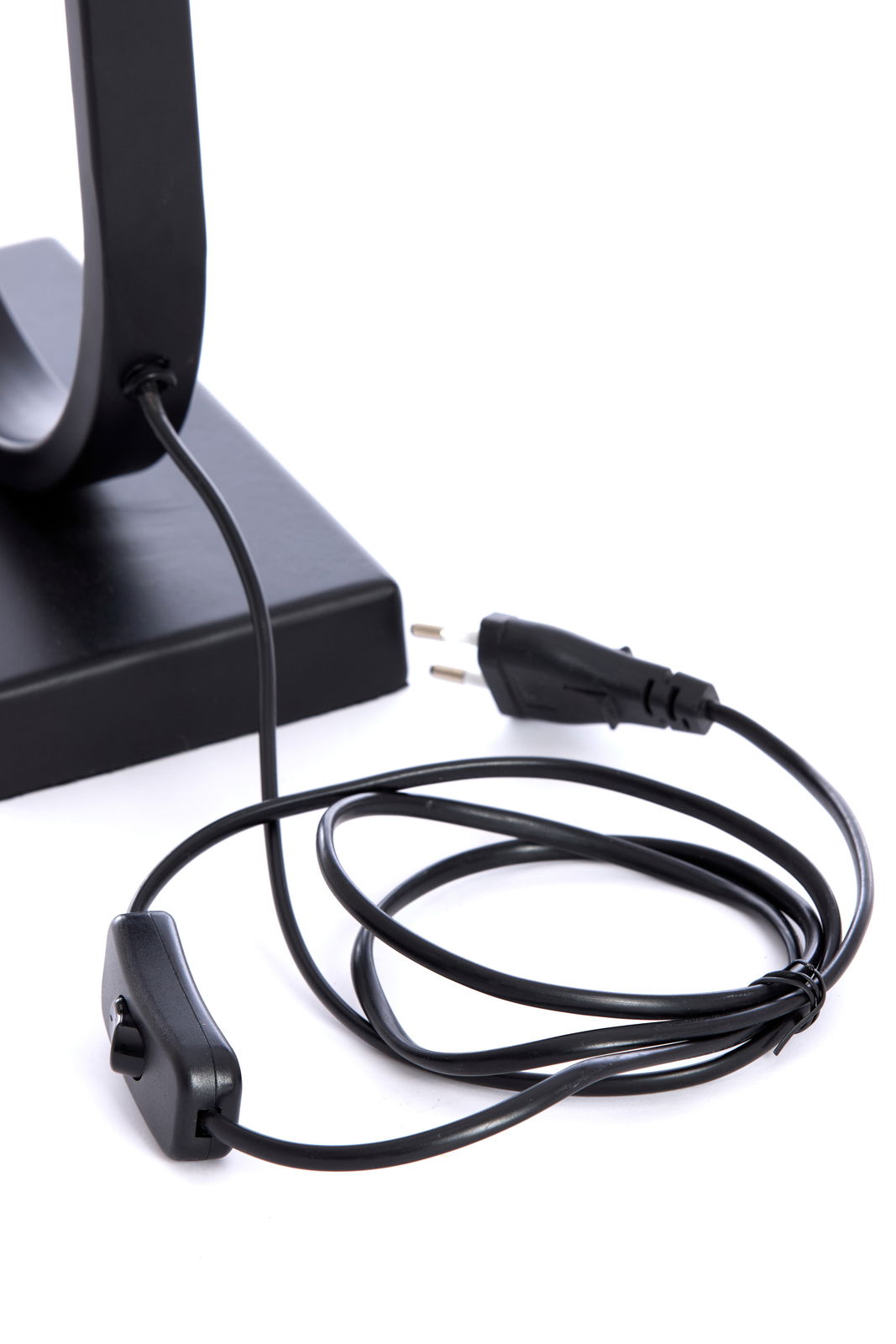 Nahaufnahme eines schwarzen Lampenfußes mit Kabel und Schalter, seitliche Perspektive.