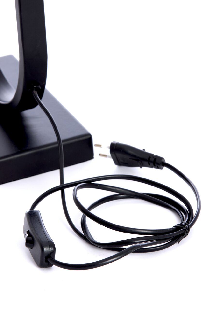 Nahaufnahme eines schwarzen Lampenfußes mit Kabel und Schalter, seitliche Perspektive.