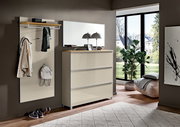 Moderne Garderoben-Kombination im Flur: Wandpaneel mit Hutablage, Kleiderhaken und Spiegel sowie passende Kommode in Beige mit Holzablage, frontal aus leicht schräger Perspektive fotografiert.