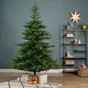 Künstlicher Weihnachtsbaum mit einer Höhe von 150 cm und einem Durchmesser von 111 cm, dekoriert mit Geschenken darunter, in einem modernen Wohnzimmer mit Regal und Dekorationen, seitliche Perspektive.