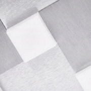 Detailansicht aus schräger Perspektive auf eine moderne geometrische Leuchte mit gebürsteten silberfarbenen Metallflächen und weiß leuchtenden Aussparungen