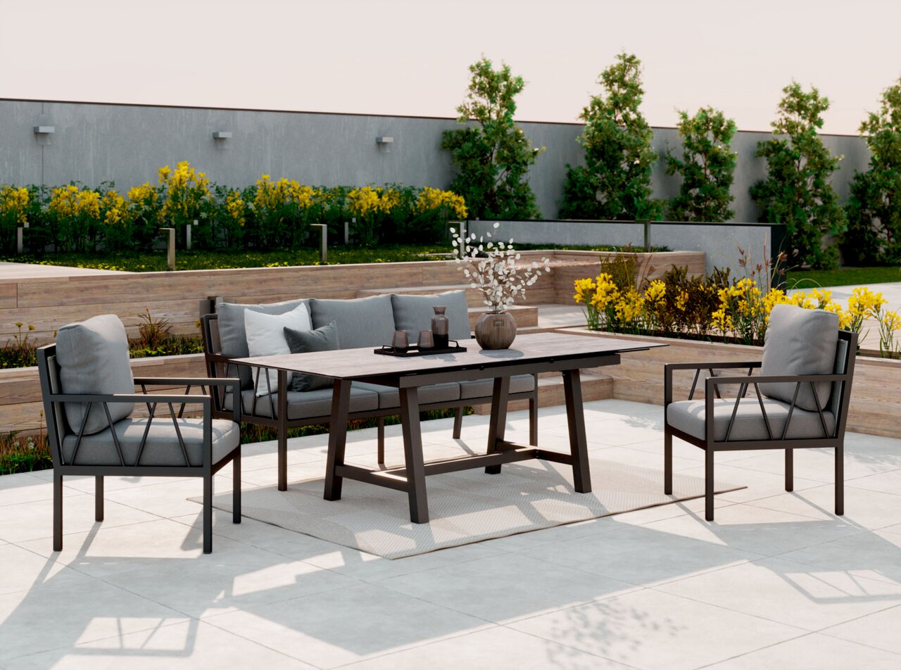 Moderne loungeset en eetset voor buiten met een zwart metalen frame, grijze kussens en een rechthoekige tafel op een lichtgekleurd terras in de tuin; perspectief: licht verhoogd vooraanzicht