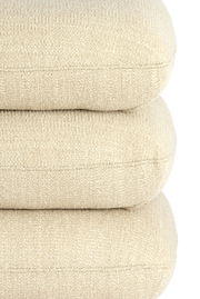 Nahaufnahme eines beigen Sitzpuffs mit strukturierter Oberfläche, gestapelt in seitlicher Perspektive.