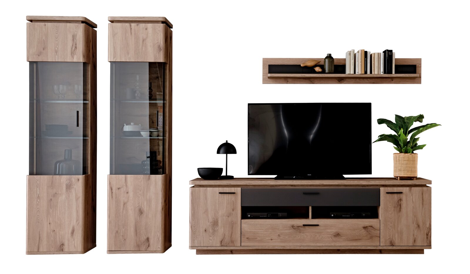 Wandmeubelset in eikenlook met twee hoge vitrinekasten met getint glas, een tv-lowboard met zwarte accenten en een wandplank, afgebeeld vanaf de voorkant tegen een witte achtergrond