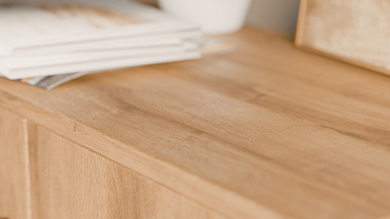 Nahaufnahme eines Schuhschranks aus Holz mit sichtbarer Maserung, von oben betrachtet.